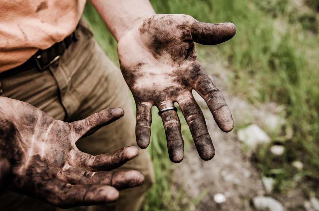 Close-up of a person's hands covered in soil.